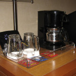 a coffee maker and coffee mugs on a tray