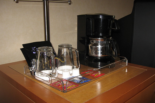 a coffee maker and coffee mugs on a tray