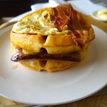a waffle with bacon and egg on a plate