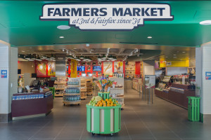 a store with a green sign and a green basket with fruit