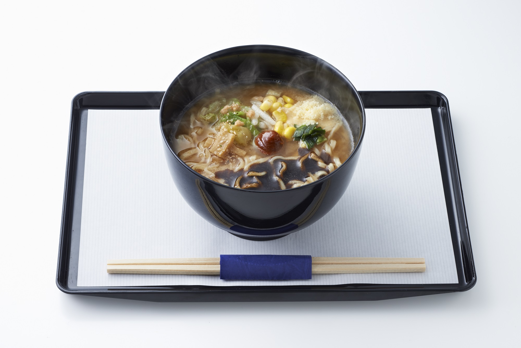a bowl of soup with chopsticks on a tray