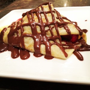 a crepe with chocolate drizzled on it