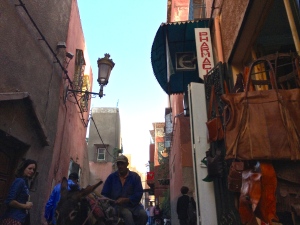 a man riding a donkey in a narrow alley