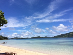 a beach with blue water and blue sky