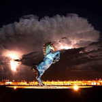 a statue of a horse with a cloud in the background