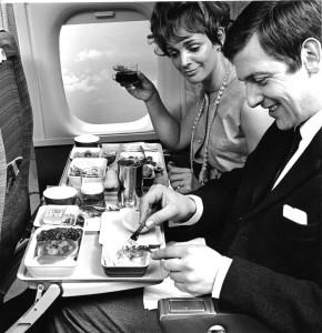 a man and woman sitting on a plane eating food