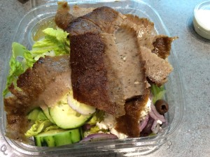 a salad with meat and vegetables in a plastic container