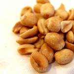 a pile of peanuts on a white surface