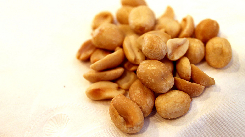 a pile of peanuts on a white surface