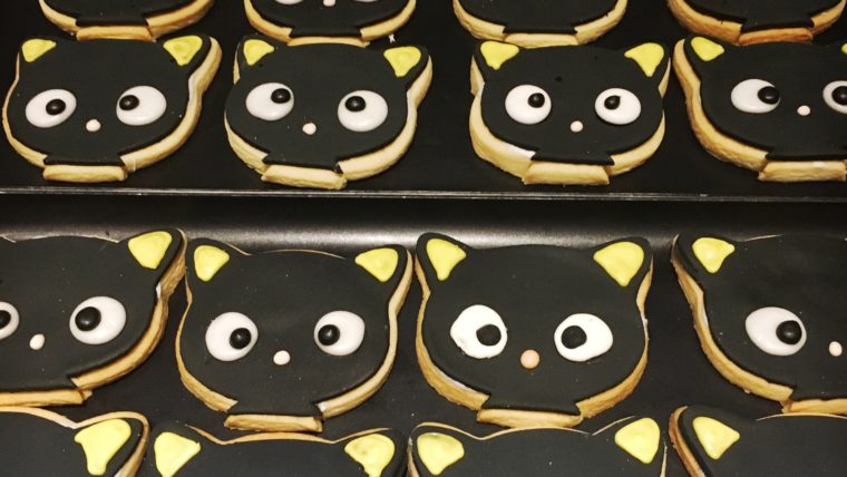 a tray of cookies with cat faces