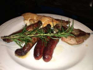 a plate of food with a sprig of rosemary