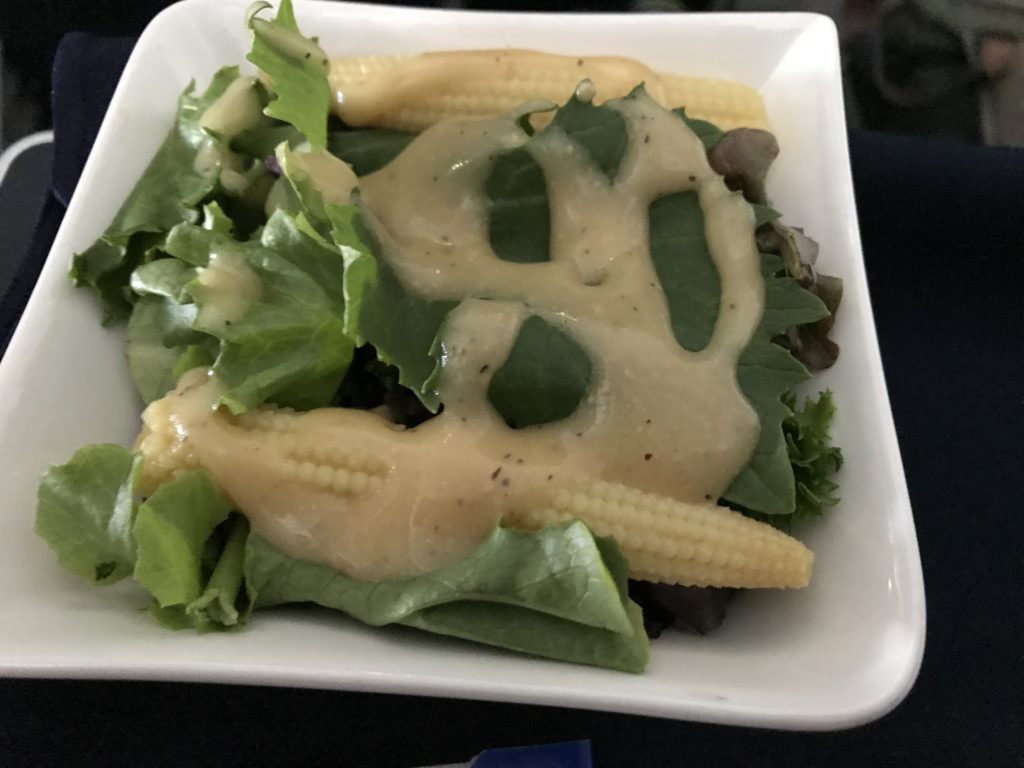 a bowl of salad with corn and sauce