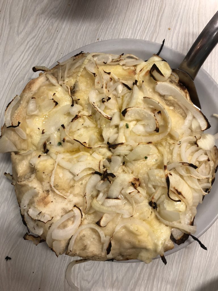 a pizza with onions on a plate