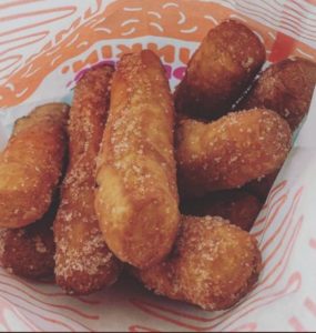 a group of fried doughnuts in a paper basket